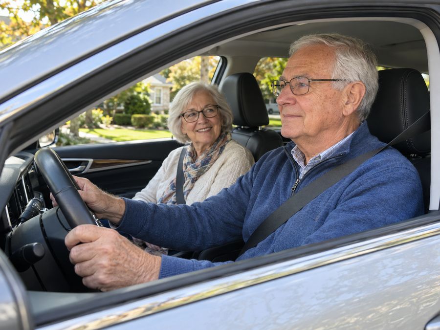 Senior driver at the wheel with his wife beside him